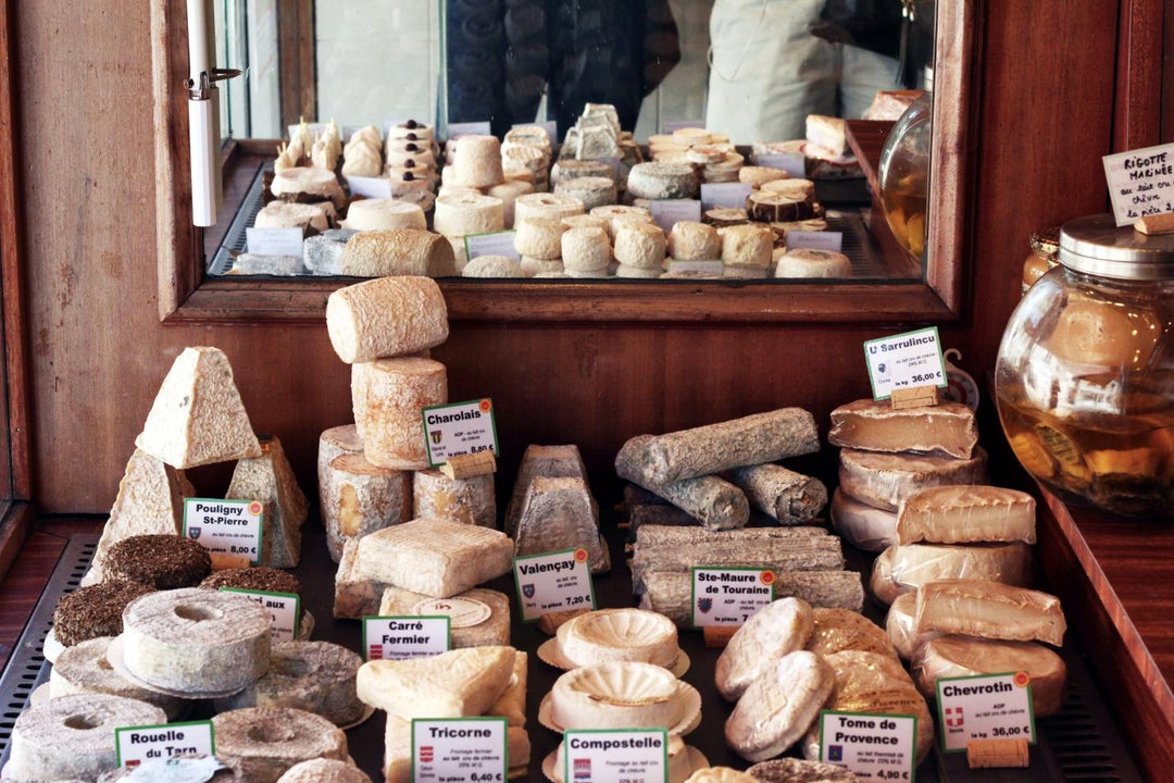 A large selection of cheeses on the counter of a small store