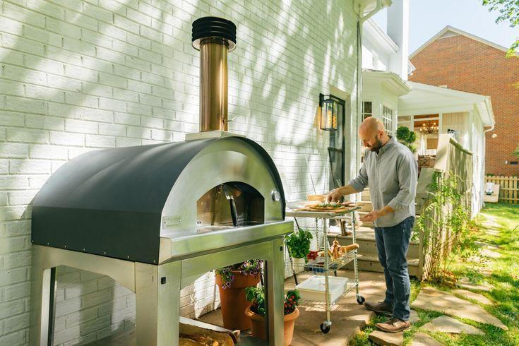 A man is making pizza in outdoor pizza ovens