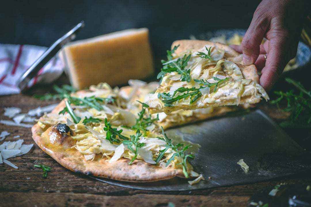 hand taking slice of italian pizza