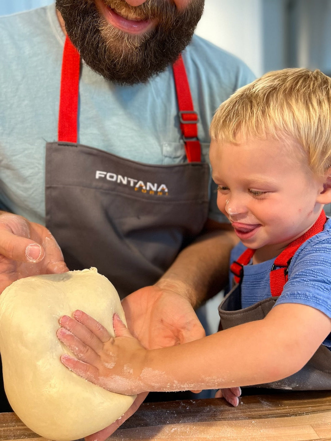 Happy smiling family in aprons cooking and kneading dough