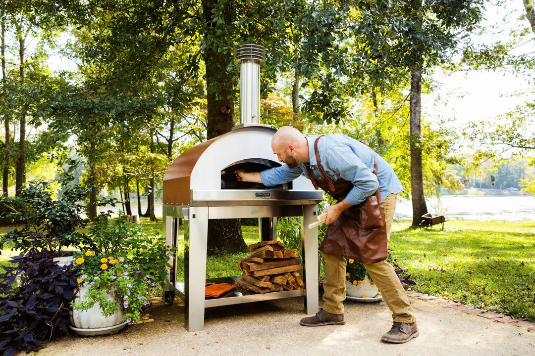 Man fueling a wood fired pizza oven from Fontana Forni