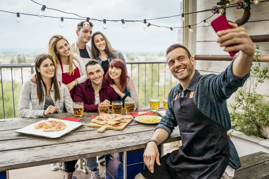 man takes a selfie before eating - Terrace party with pizza