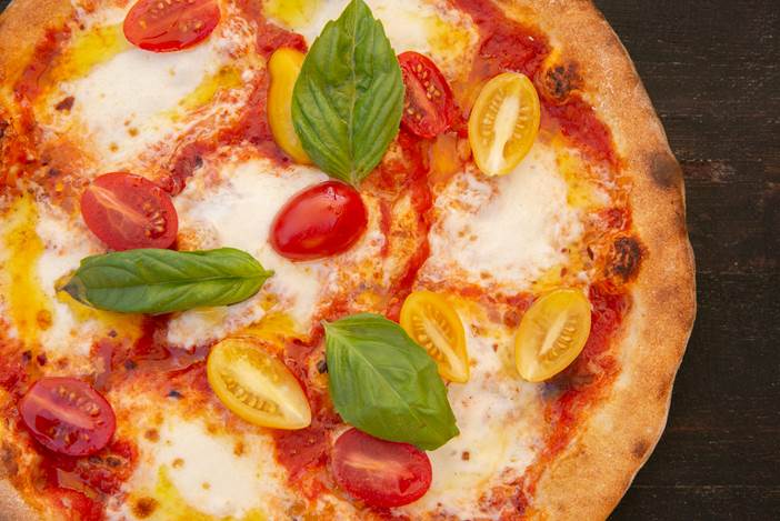 pizza margherita with tomato topped