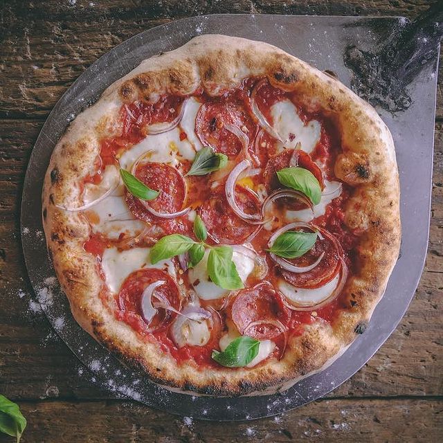 rustic italian pizza with mozzarella, cheese and basil leaves
