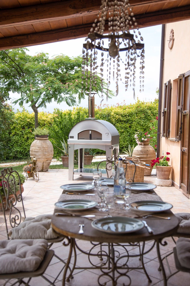 tables and chairs in outdoor with wood fired Ppizza ovens