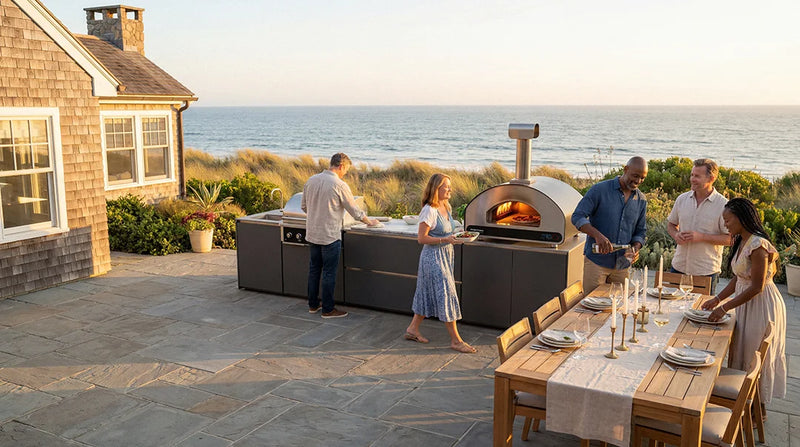 ember outdoor kitchen and a group of friends about to eat pizza by the coast
