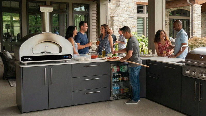 Elysia Outdoor kitchen with people socializing, featuring a Volta pizza oven and grill.