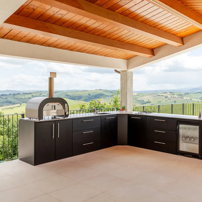 Elysia Outdoor Kitchen in L shape configuration on stone patio under a roof overlooking green hills