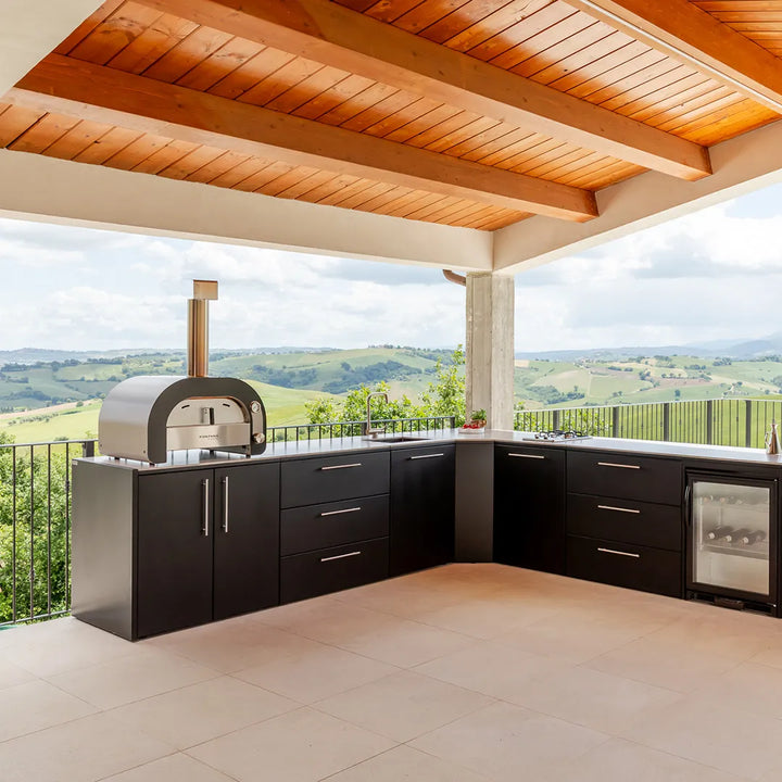 Elysia Outdoor Kitchen in L shape configuration on stone patio under a roof overlooking green hills