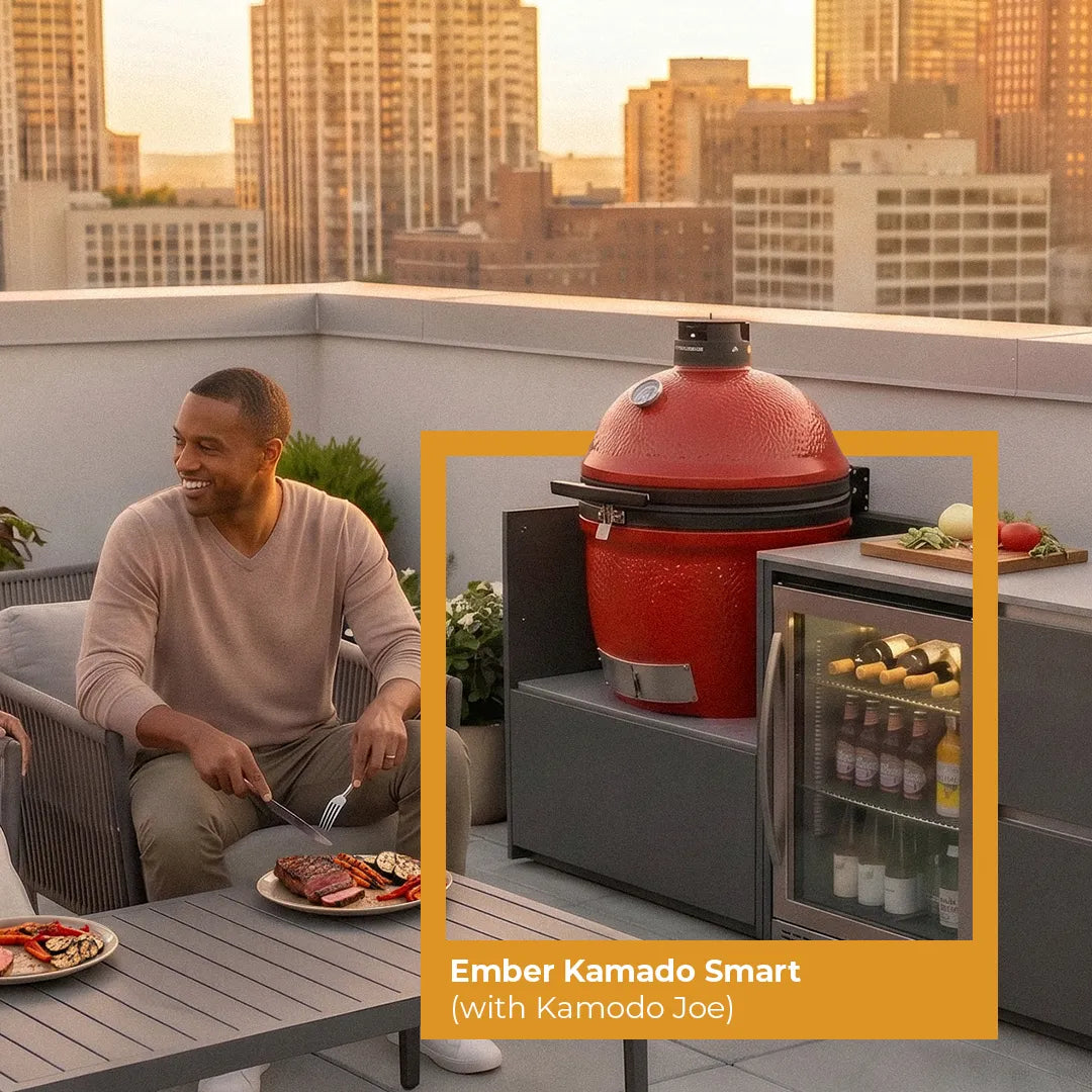 Man on a rooftop about to enjoy dinner he cooked on a Ember red Kamado Smart with a Red Kamado Joe and city skyline in the background.