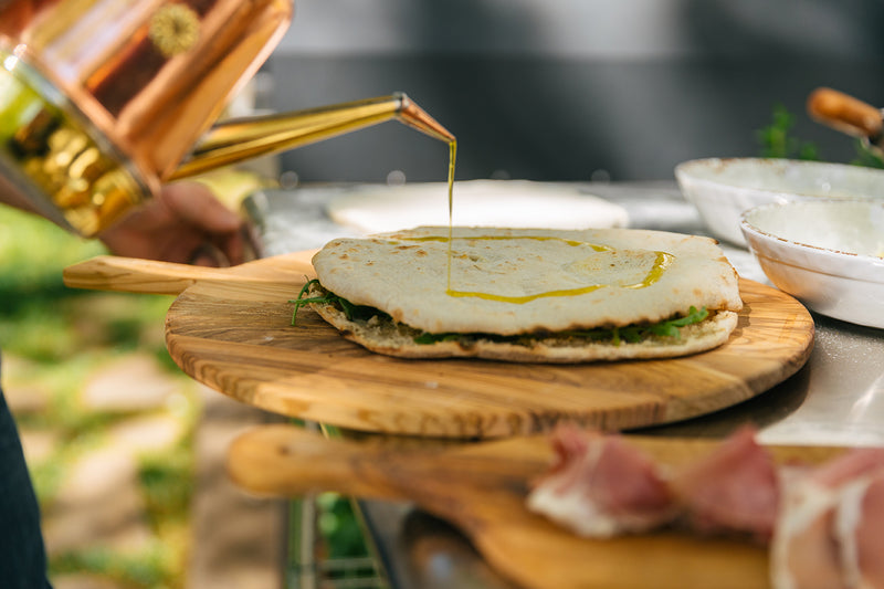 Pouring a Copper Oil Cruet on Pizza Dough