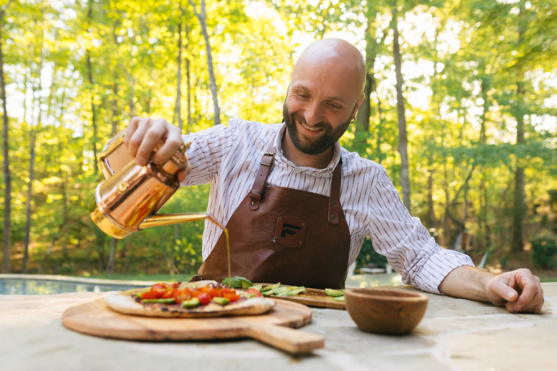 Man Pouring From a Copper Oil Cruet